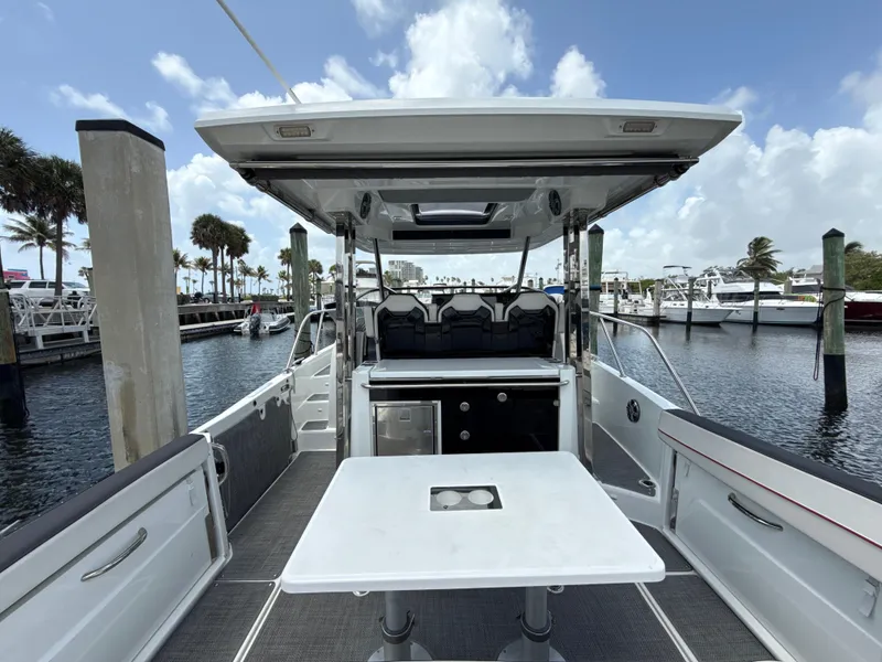 Slide: The Image of 2022 Jeanneau Leader 10.5 WA Series 2 boat interior at marina, featuring seating and table. - 11