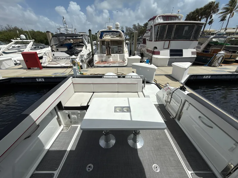 Slide: The Image of 2022 Jeanneau Leader 10.5 WA Series 2 at marina, featuring spacious deck and seating area. - 12
