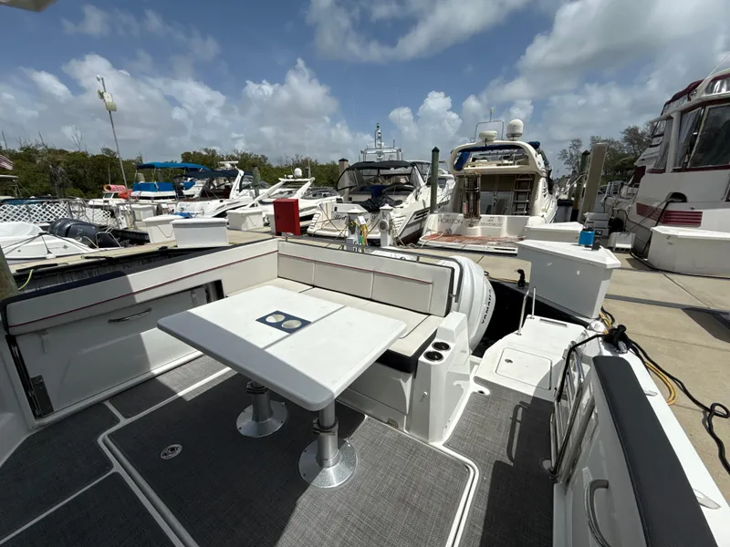 Slide: The Image of 2022 Jeanneau Leader 10.5 WA Series 2 boat docked, featuring spacious seating and table. - 13