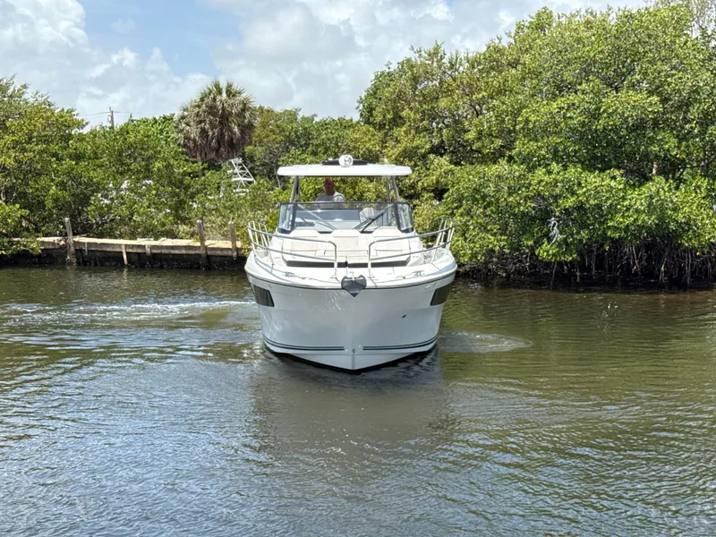 Slide: The Image of 2022 Jeanneau Leader 10.5 WA Series 2 cruising on a calm waterway surrounded by greenery. - 2