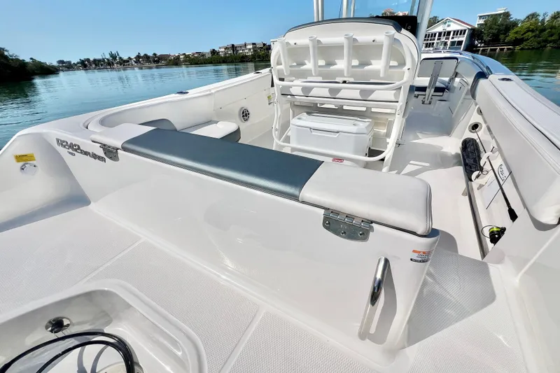 Slide: The Image of 2021 Robalo R242 Explorer boat interior with seating and storage, docked on a serene lake. - 10