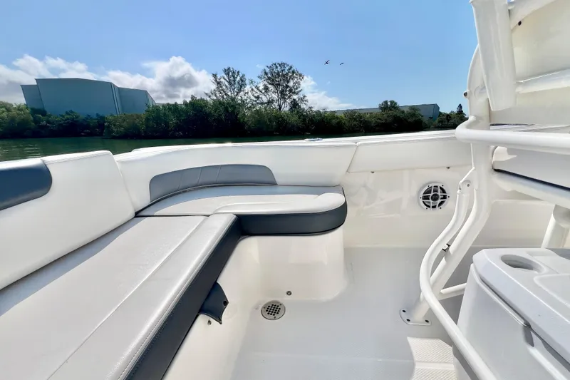 Slide: The Image of 2021 Robalo R242 Explorer boat interior with cushioned seating and scenic water view. - 13