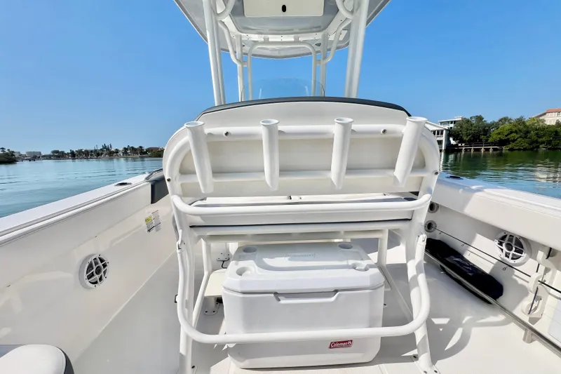 Slide: The Image of 2021 Robalo R242 Explorer boat interior with rod holders and cooler on a sunny day. - 15