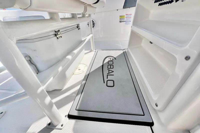 Slide: The Image of 2021 Robalo R242 Explorer boat interior with storage compartments and branded mat. - 19