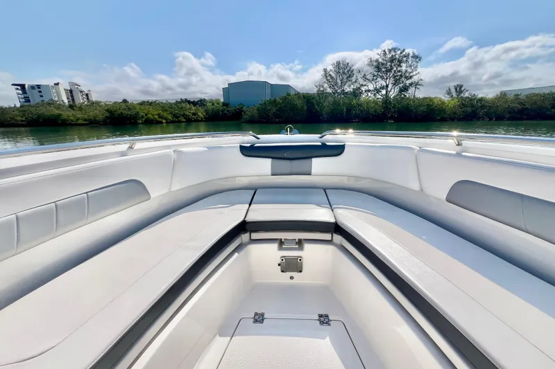 Slide: The Image of 2021 Robalo R242 Explorer boat interior with sleek seating, surrounded by scenic water and greenery. - 23