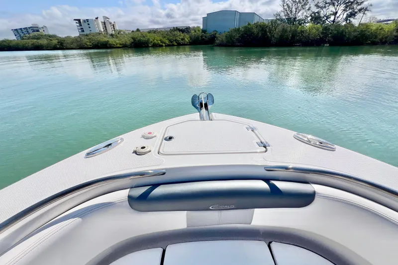 Slide: The Image of 2021 Robalo R242 Explorer boat on calm water with scenic shoreline view. - 25
