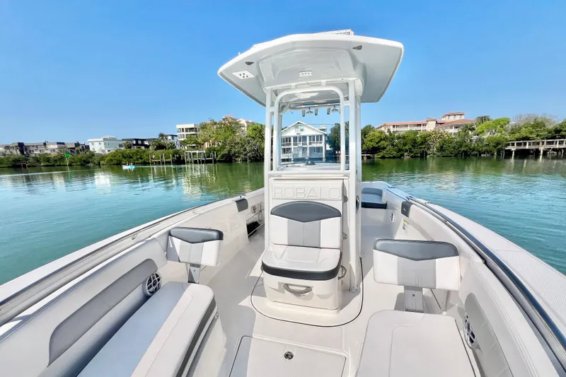Slide: The Image of 2021 Robalo R242 Explorer boat on calm water, showcasing spacious seating and sleek design. - 27