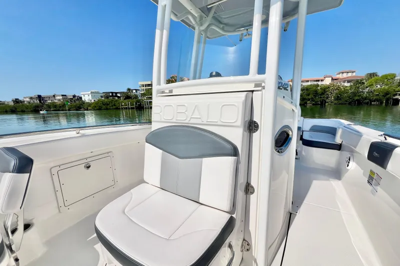 Slide: The Image of 2021 Robalo R242 Explorer boat interior with seating, on a sunny day by the water. - 28