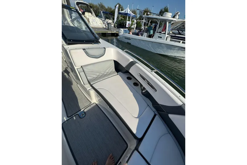 Slide: The Image of 2021 Chaparral 317 SSX boat interior with luxurious seating at a marina. - 21