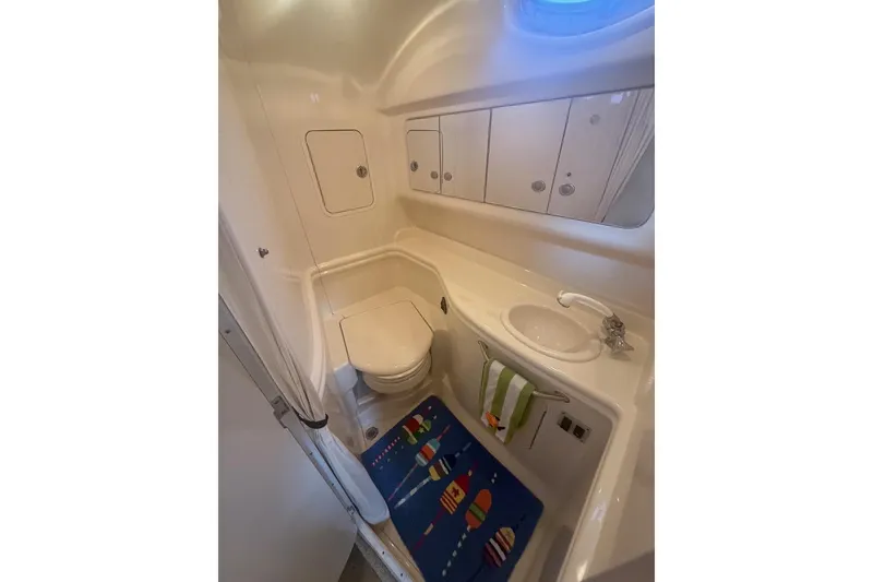 Slide: The Image of 2006 Sea Ray Sundancer 320 bathroom with toilet, sink, and colorful mat. - 13