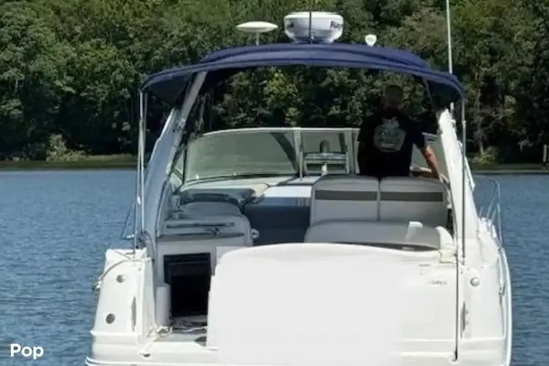 Slide: The Image of 2006 Sea Ray Sundancer 320 yacht on calm water, surrounded by lush greenery. - 3