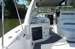 Slide: The Image of 2006 Sea Ray Sundancer 320 boat interior with "Island Time" nameplate, docked by lush greenery. - 6