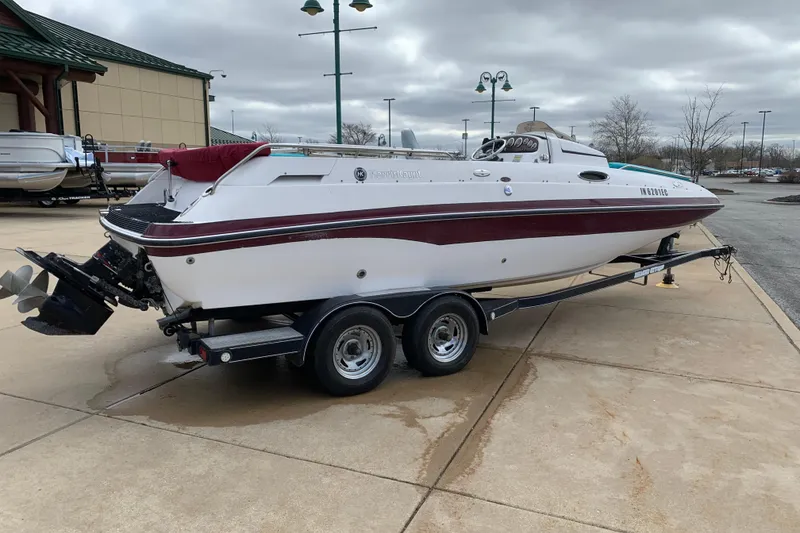 The Image of 2000 Harris-Kayot 226 Super Deck boat on trailer, parked outdoors under cloudy skies. - 0