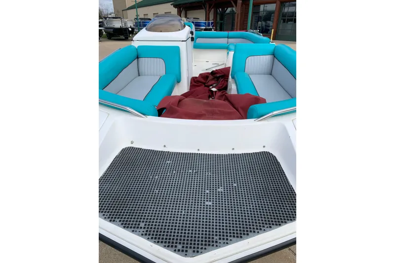 Slide: The Image of 2000 Harris-Kayot 226 Super Deck boat with teal and gray seating, docked outdoors. - 1