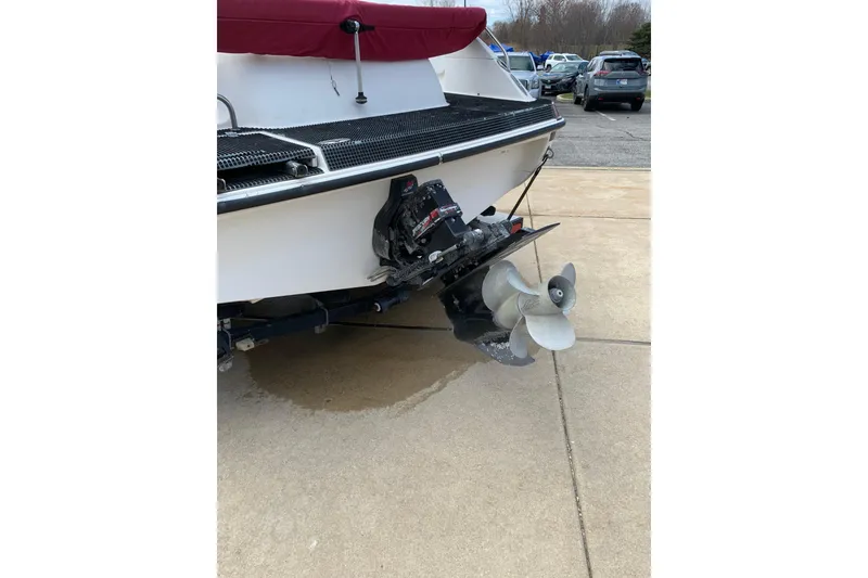 Slide: The Image of 2000 Harris-Kayot 226 Super Deck boat with visible propeller and stern, parked on pavement. - 3