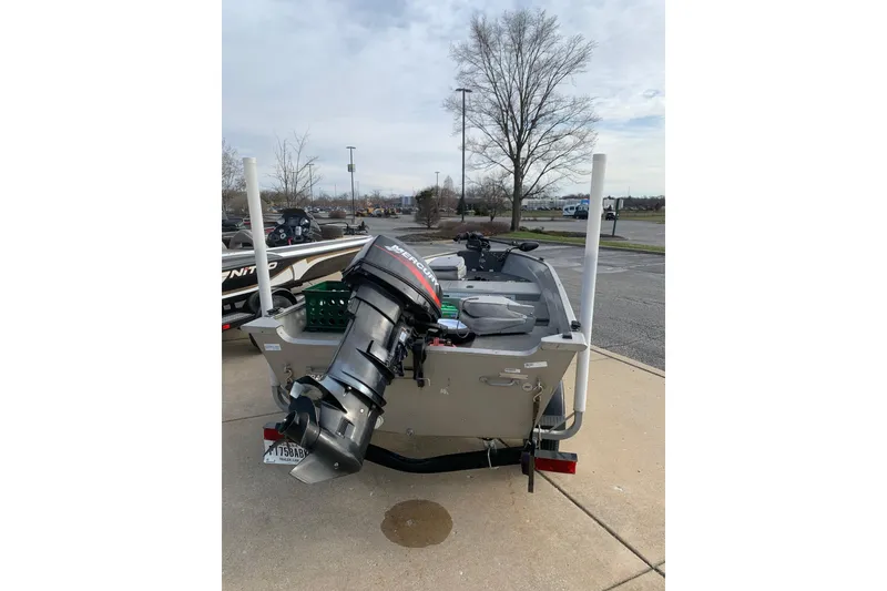 Slide: The Image of 2007 Bass Tracker Super Guide boat with Mercury outboard motor, parked outdoors. - 4