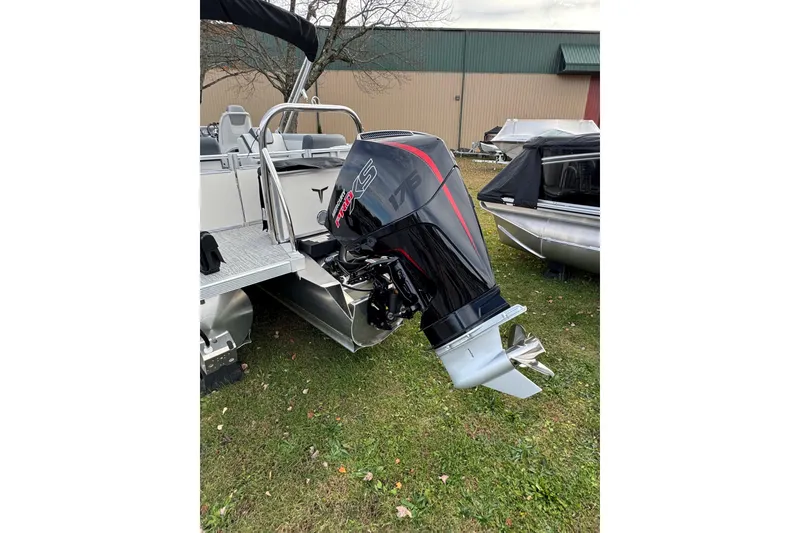 Slide: The Image of 2026 Tahoe Pontoon LTZ Quad Lounger 23 with powerful outboard motor on grass. - 12