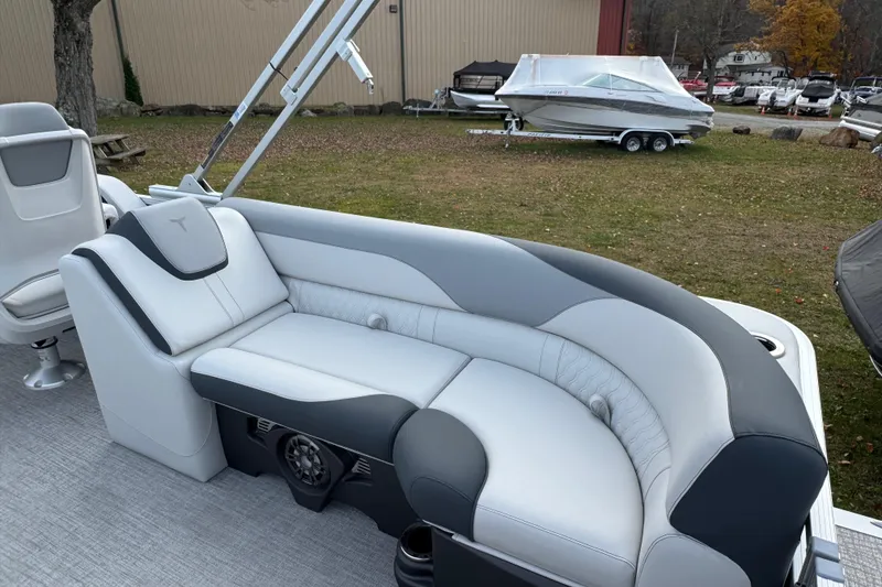 Slide: The Image of 2026 Tahoe Pontoon LTZ Quad Lounger 23 with luxurious seating, parked outdoors. - 9