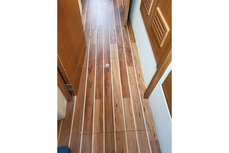 Slide: The Image of Wooden interior flooring of a 1996 Bertram 46 Convertible yacht hallway. - 10
