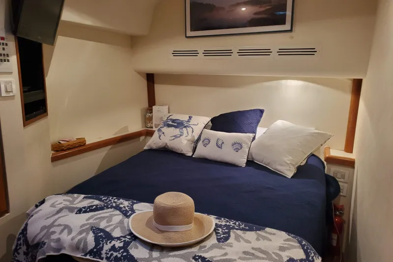 Slide: The Image of Cozy bedroom interior of 1996 Bertram 46 Convertible yacht with nautical-themed decor. - 13