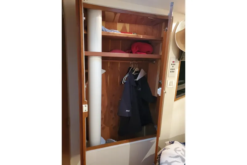 Slide: The Image of Open closet on a 1996 Bertram 46 Convertible yacht, displaying jackets and shelves. - 14