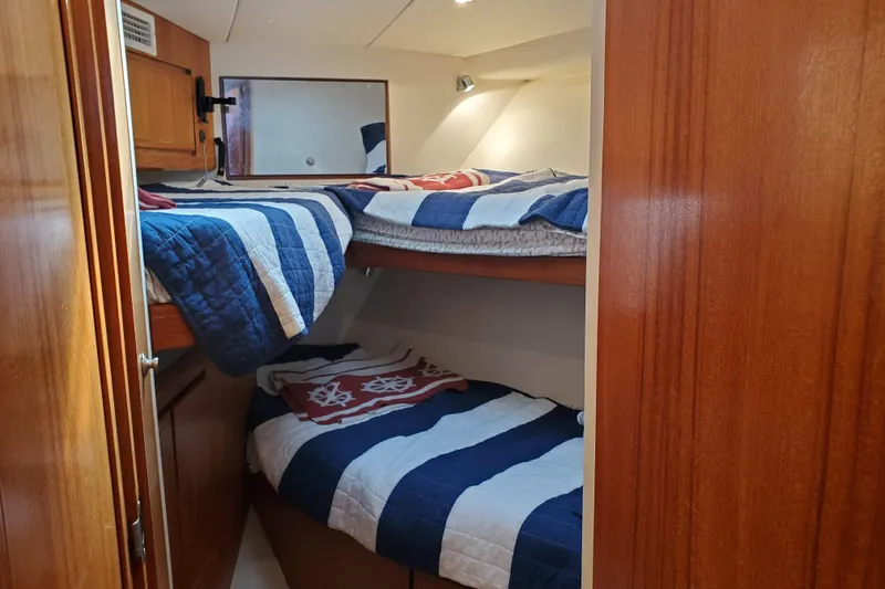 Slide: The Image of Cozy bunk beds in 1996 Bertram 46 Convertible yacht cabin with nautical-themed bedding. - 19