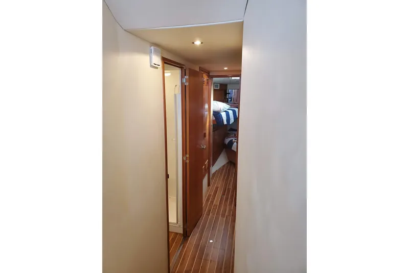 Slide: The Image of Hallway inside 1996 Bertram 46 Convertible yacht, featuring wooden flooring and cabin access. - 20