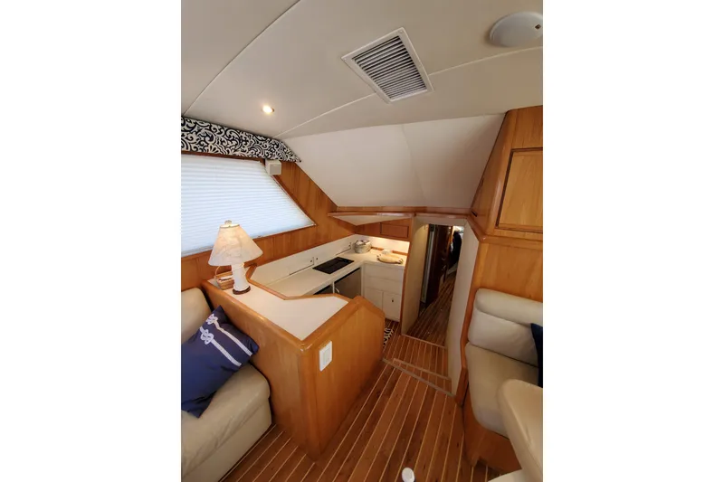 Slide: The Image of Interior of 1996 Bertram 46 Convertible yacht with cozy seating and elegant wood finishes. - 21