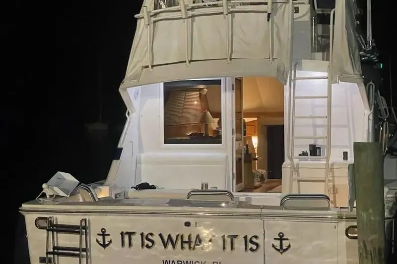 Slide: The Image of 1996 Bertram 46 Convertible yacht named "It Is What It Is" docked at night. - 4