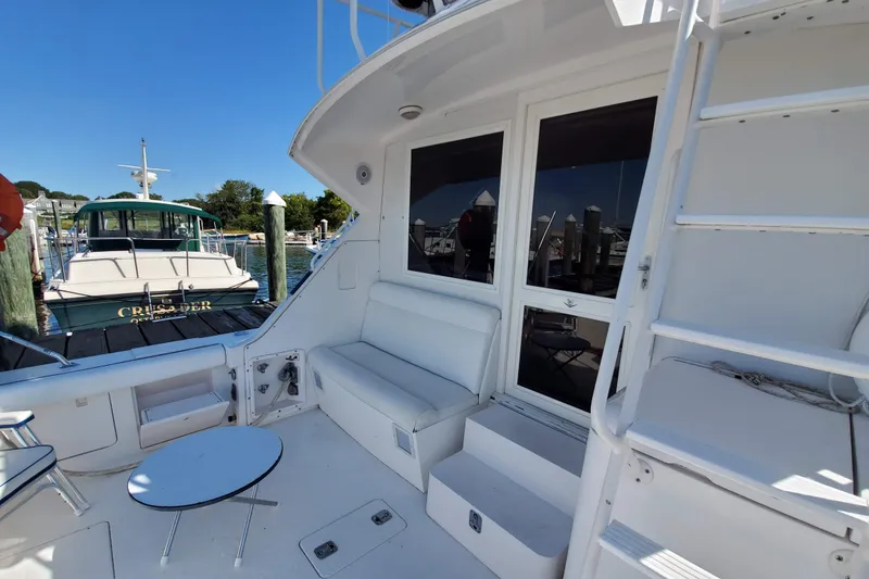 Slide: The Image of 1996 Bertram 46 Convertible yacht interior with seating, table, and ladder in a marina setting. - 5