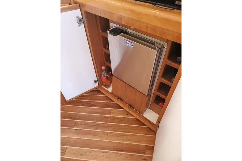 Slide: The Image of 1996 Bertram 46 Convertible yacht interior with wooden cabinetry and built-in fridge. - 8