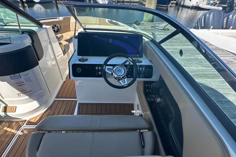 Slide: The Image of 2019 Sea Ray SLX 280 boat cockpit with steering wheel and dashboard, docked at marina. - 19