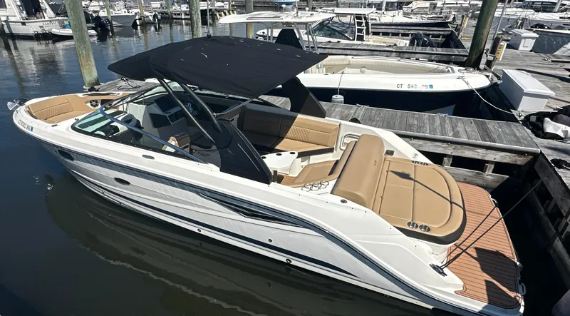 Slide: The Image of 2019 Sea Ray SLX 280 boat docked, featuring sleek design and spacious seating. - 2