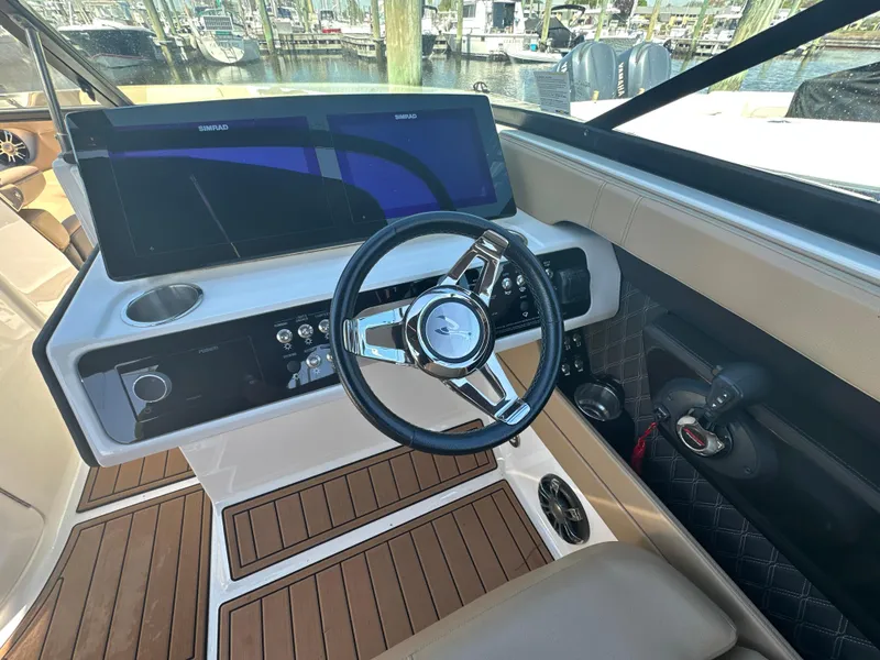 Slide: The Image of 2019 Sea Ray SLX 280 helm with modern steering wheel and dashboard controls. - 21