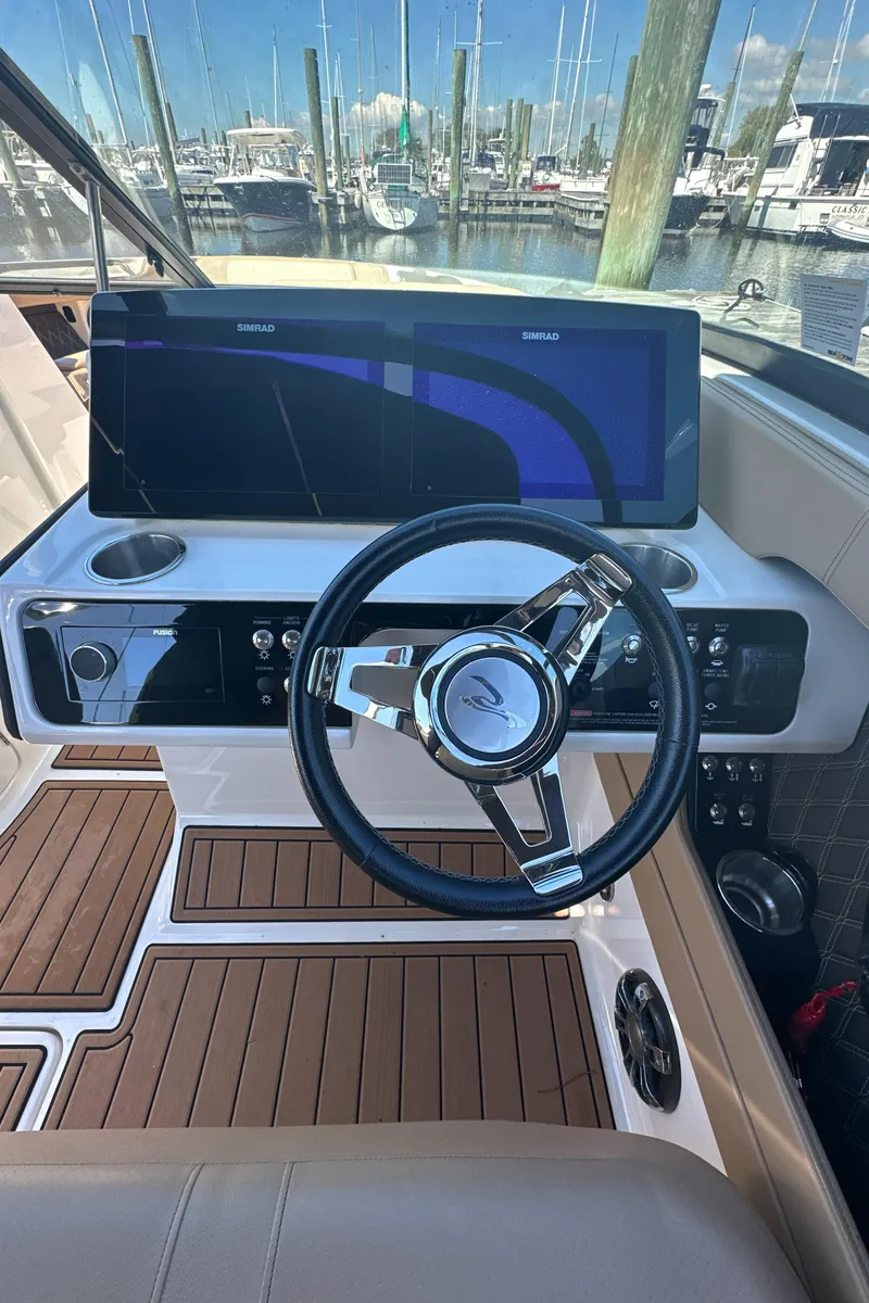 Slide: The Image of 2019 Sea Ray SLX 280 boat dashboard with steering wheel and navigation screen. - 24