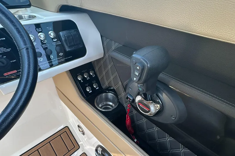 Slide: The Image of 2019 Sea Ray SLX 280 helm controls with throttle, switches, and cup holder. - 25