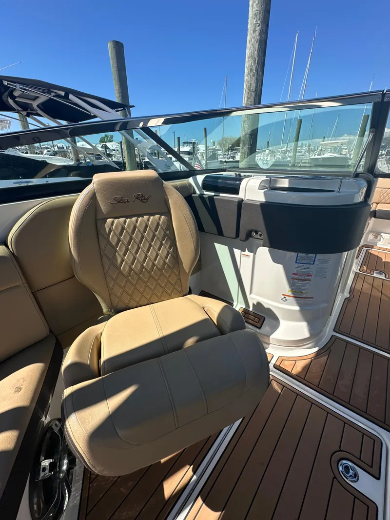 Slide: The Image of 2019 Sea Ray SLX 280 boat interior with tan seating and wood flooring. - 28