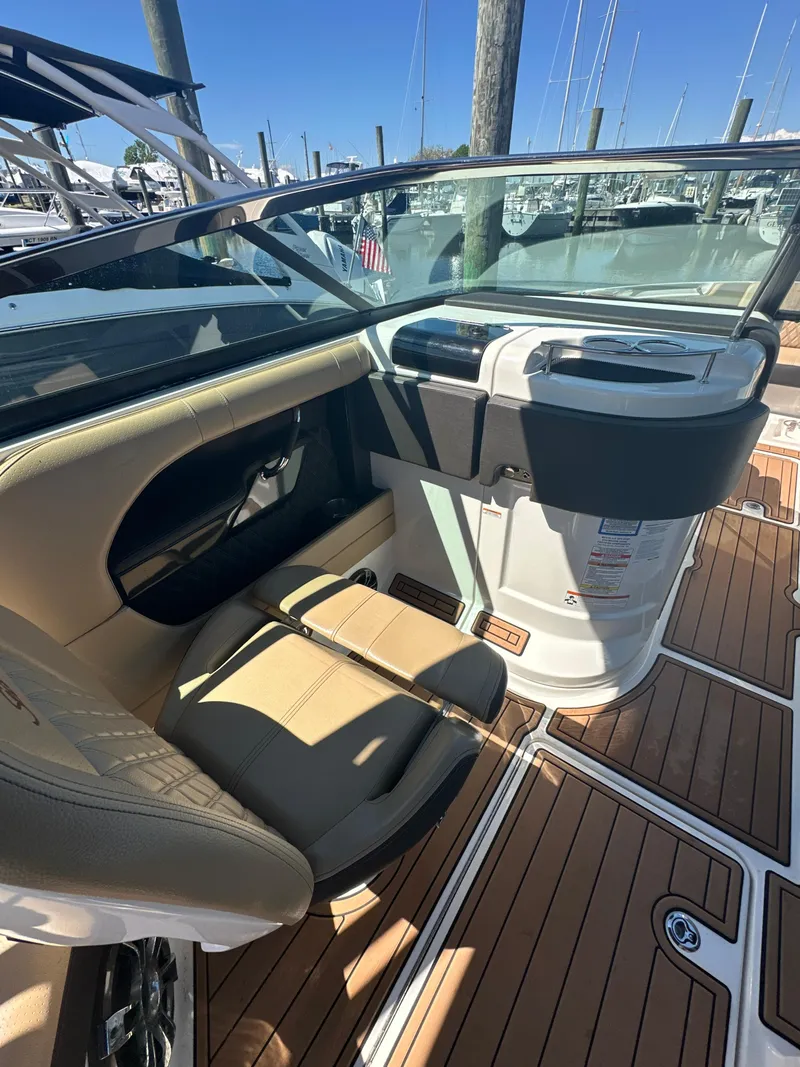 Slide: The Image of 2019 Sea Ray SLX 280 boat interior with tan seating and wood-style flooring. - 29