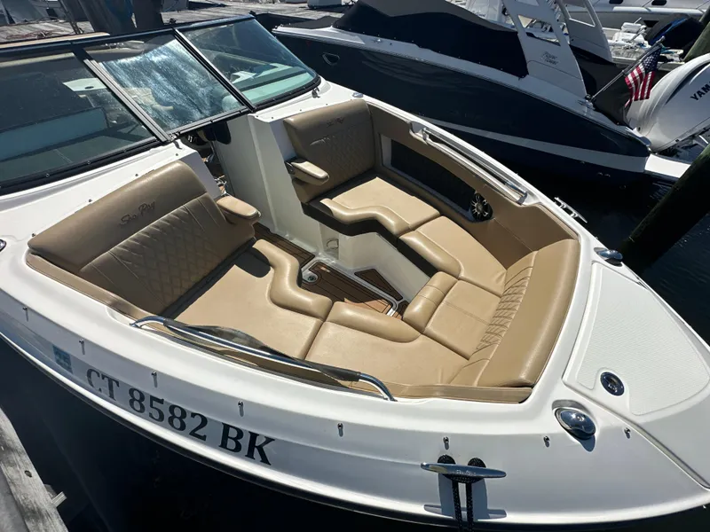 Slide: The Image of 2019 Sea Ray SLX 280 boat with tan leather seating, docked at a marina. - 30