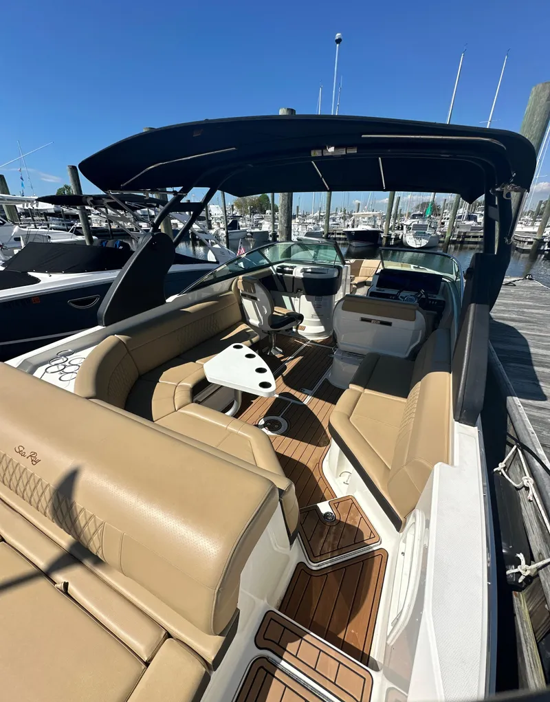 Slide: The Image of 2019 Sea Ray SLX 280 boat with tan seating and sleek design, docked at a marina. - 34