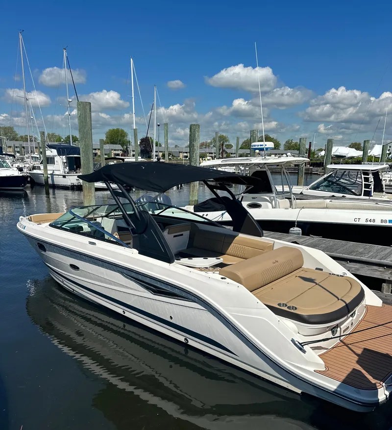 Slide: The Image of 2019 Sea Ray SLX 280 boat docked at marina under clear blue sky. - 4