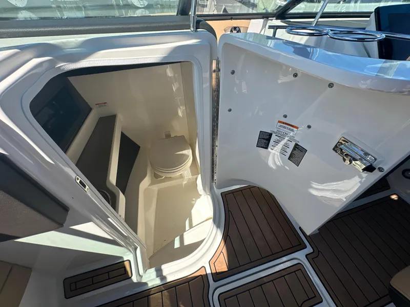Slide: The Image of 2019 Sea Ray SLX 280 boat interior with open cabin door and visible toilet. - 44