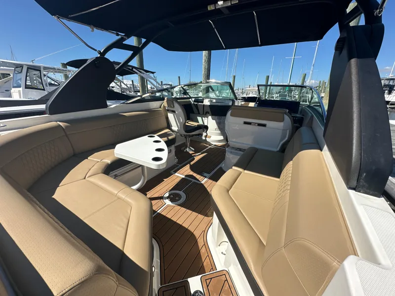 Slide: The Image of 2019 Sea Ray SLX 280 boat interior with tan seating and wood flooring. - 5