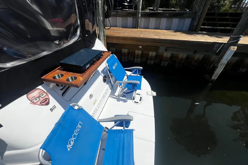 Slide: The Image of 2003 Sea Ray 410 Express Cruiser docked with blue chairs and a small table. - 10