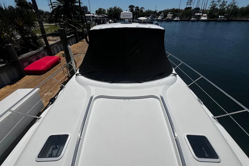 Slide: The Image of 2003 Sea Ray 410 Express Cruiser docked at marina, featuring sleek white deck design. - 11