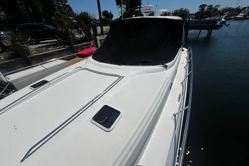 Slide: The Image of 2003 Sea Ray 410 Express Cruiser docked, featuring sleek white deck and railing. - 12