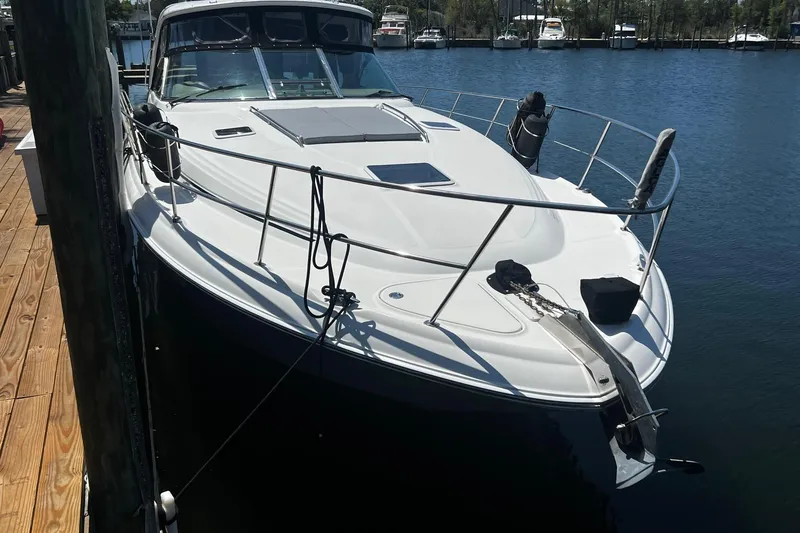 Slide: The Image of 2003 Sea Ray 410 Express Cruiser docked at marina, showcasing sleek design and spacious deck. - 13