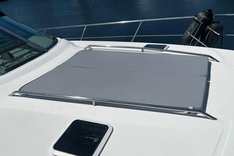 Slide: The Image of 2003 Sea Ray 410 Express Cruiser deck with sunpad and railing, overlooking water. - 18