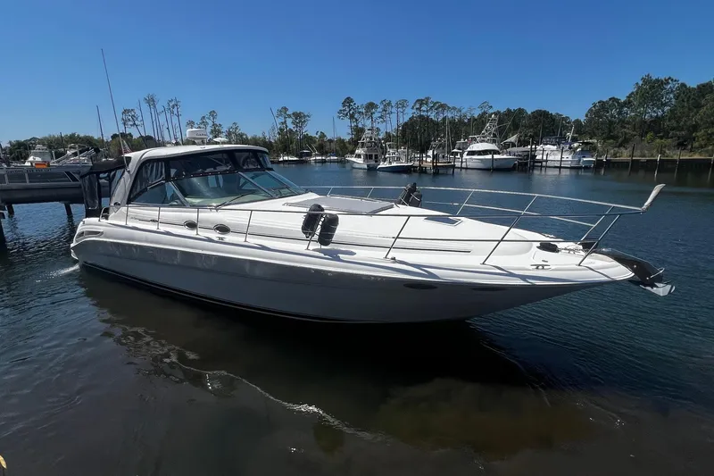 Slide: The Image of 2003 Sea Ray 410 Express Cruiser docked in a serene marina setting. - 2