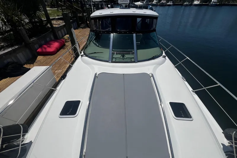 Slide: The Image of 2003 Sea Ray 410 Express Cruiser docked, showcasing sleek deck design and waterfront setting. - 20